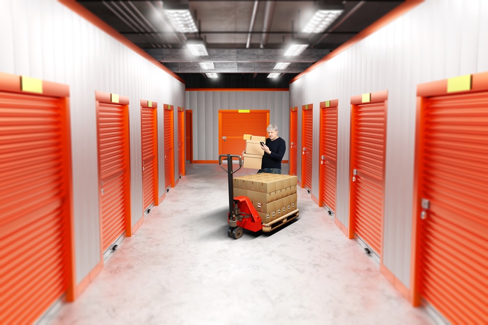 Storage,Units,Rent.,Man,In,Warehouse,Hallway.,Guy,Carries,Boxes